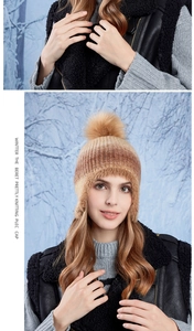Detail of warm winter knit hat featuring plush faux fur lining and pompom decoration