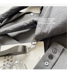 Detailed macro view of the silver hardware and quilted gray nylon texture of the tote bag