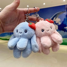Detail of pink and blue plush octopus keychains with strawberry hats and metal rings