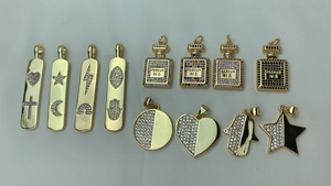 Macro shot of gold-plated charms featuring micro-pave cubic zirconia in various shapes