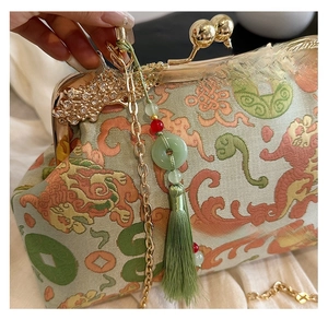Close-up of vintage embroidered evening bag with silk tassel and golden clasp hardware