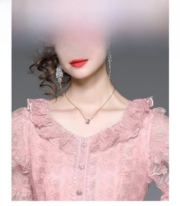 Close-up of pink heavy embroidery lace dress with ruffle neckline and floral patterns