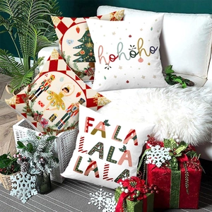 Set of four Christmas cushion covers with festive slogans on a cozy white sofa