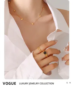 Gros plan sur l'ensemble collier coeur doré et bague chevalière smiley pour femme