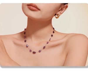 Macro shot of bohemian irregular purple natural stones on a stainless steel gold necklace
