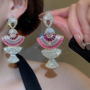 Detailed close-up of luxurious fan-shaped earrings with colorful crystals and sparkling rhinestones