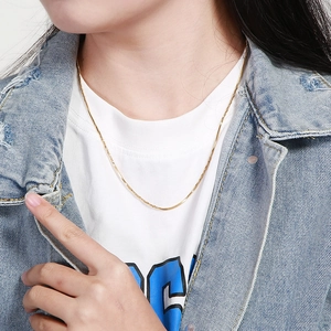 Close-up of a minimalist golden snake chain necklace on a model's neck for elegant styling