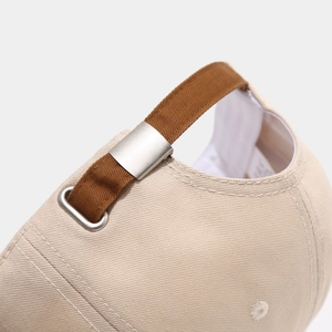 Detailed close-up of adjustable metal buckle and brown strap on cotton baseball cap