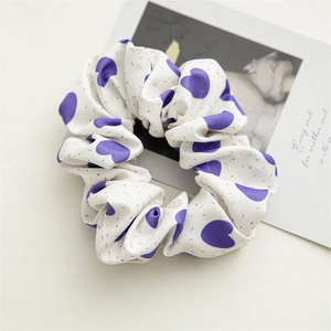 Detail of white scrunchie with purple heart print and pink accents on a card