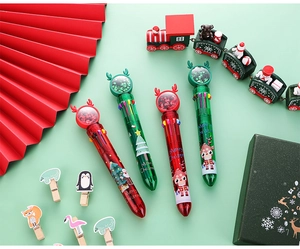 Close-up of Christmas 10-color ballpoint pens with festive sequins and holiday decorations