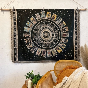 Detail of bohemian woven tapestry featuring zodiac wheel and mystic sun with fringe edges