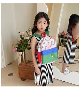 Detail shot of canvas preschool backpack with red checkered pattern and contrast pockets