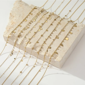Chic gold titanium necklaces with star, heart, and coin charms on a stone surface