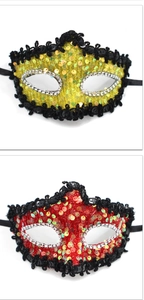 Detail of red and yellow sequin masquerade masks with lace edges and black ribbons