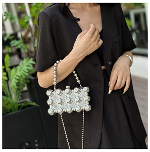 Detail of silver beaded handbag with metallic beads and dual chain straps in a lifestyle view