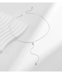 Macro detail of elegant gold Y-shaped necklace with shimmering clear crystal accents
