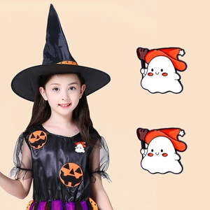 Detail of cute ghost Halloween brooches with wizard hats on a child model's sweater