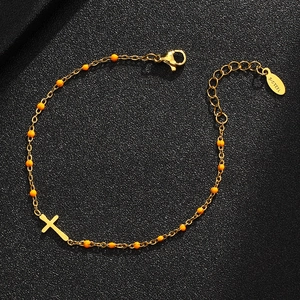 Detail of gold stainless steel cross bracelet with orange beads and lobster clasp