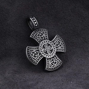 Macro shot of silver stainless steel Celtic cross pendant with intricate knot textures