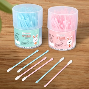 Close-up of double-headed cotton swabs with a plastic ear scoop in pink and blue containers