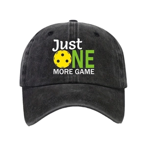 Faded black cotton baseball cap with Just One More Game print and yellow pickleball icon
