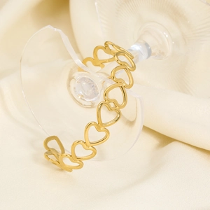Detailed view of hollow heart-shaped gold bangle over broken glass and silk background