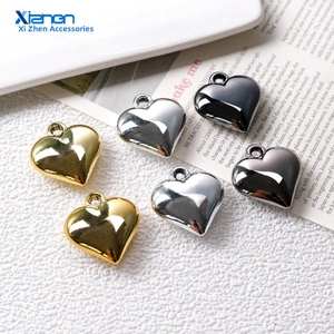Macro detail of heart-shaped pendants in gold, silver, and gun black polished finishes