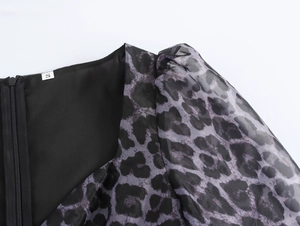 Detail view of leopard print puff sleeves and back zipper on black dress size S