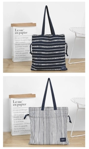 Close-up of drawstring canvas tote bags with wave and stripe patterns on a stylish chair
