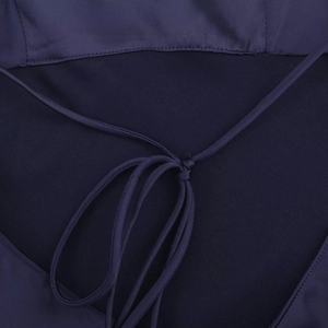 Detaillierte Makroansicht des dunkelblauen Satin-Kleides mit Schnürung und seidiger Textur