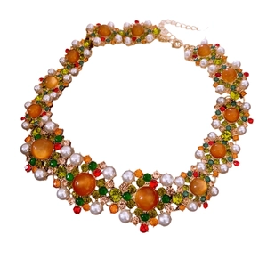 Vintage-Halsketten-Set mit orangefarbenen Perlen und bunten Kristallen auf Weiß