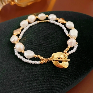 Detail of double-layer freshwater pearl bracelet with golden toggle clasp on velvet