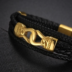 Détail du bracelet multicouche en cuir tressé noir avec boucle magnétique gravée dorée
