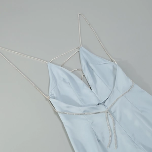 Detail of light blue satin dress featuring sparkling rhinestone chain straps and deep V-neck