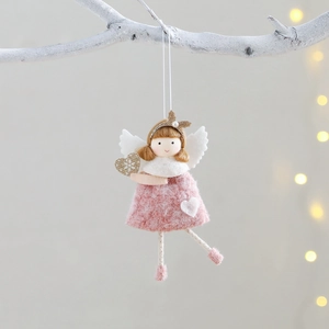 Pink handmade plush Christmas angel ornament with golden crown hanging on white tree branches