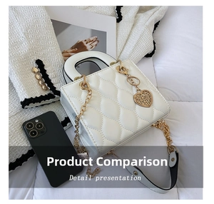 Detailed view of white quilted handbag with golden chain strap and heart charm