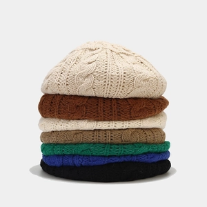 Women's cable knit beret hats in multiple colors stacked vertically on a light grey background
