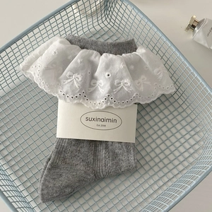 Grey crew socks with delicate white lace trim and bow embroidery in a blue basket