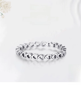 Detail of silver S925 heart-shaped band ring with romantic repeating heart pattern