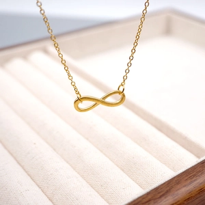 Elegant gold infinity symbol necklace with fine link chain on a premium jewelry box