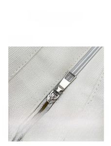 Detailed close-up showing the smooth silver metal zipper on off-white canvas fabric