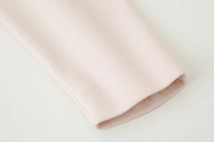 Close-up of the cuff details on a light pink wool-blend short double-breasted coat