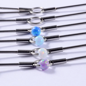 Macro shot of stainless steel industrial barbells with opal beads in blue white and purple