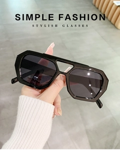 Detailed view of the thick black geometric frames and smooth cut of the fashion sunglasses