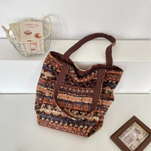 Detail of vintage knit tote bag with orange and brown patterns on a white background