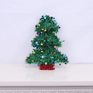 Miniature green tinsel Christmas tree with colorful sequins on a festive red base