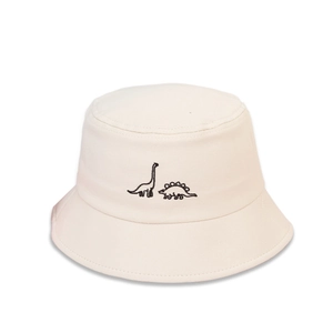 Détail de la broderie de dinosaure sur le chapeau bob en coton crème pour enfants
