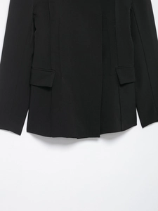 Detail view of the hem and flap pockets on a black slim-fit high-neck blazer jacket