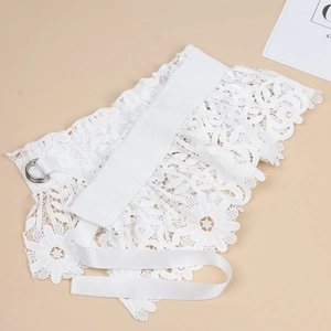 Detailed view of floral white lace belt with dual silver metal rings and webbing texture