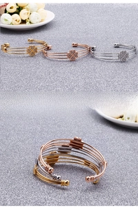 Dettaglio di bracciali a tre strati con quadrifoglio di diamanti in oro e oro rosa lucido
